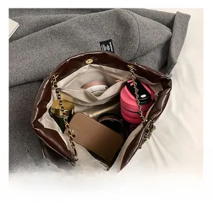 Deep brown quilted tote bag showing spacious interior with golden chain strap detail
