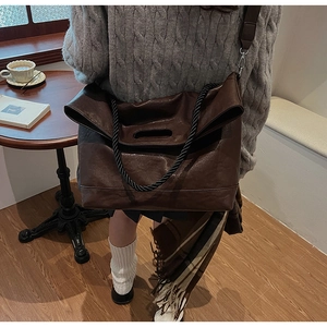 Détail du grand sac cabas en cuir souple marron avec poignées tressées et bandoulière