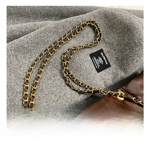 Detail of dark brown quilted leather handbag with premium gold metal chain strap