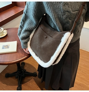 Detail of faux suede bucket bag with plush trim and leather strap in cafe setting