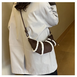 Detail of crossbody crescent bag with plush white trim and dark brown leather texture