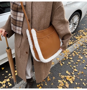 Close-up of caramel leather crossbody bag with white faux fur trim in autumn setting