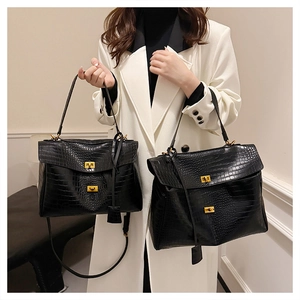 Detail view of premium black crocodile embossed tote bags with golden metal twist locks