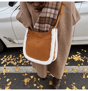Dettaglio di borsa a sella in pelle scamosciata marrone con bordo in shearling bianco su modella