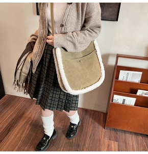 Detail of olive green suede bucket bag with white faux shearling trim and slim strap