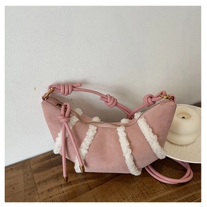 Close-up of pink frosted leather crescent bag with white faux shearling stripe details