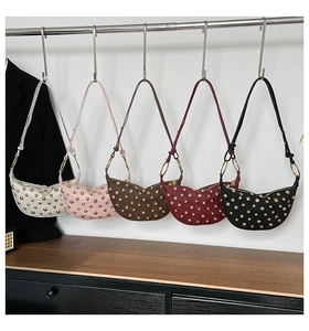 Détail de sacs à bandoulière en cuir en forme de croissant avec rivets dorés en cinq couleurs