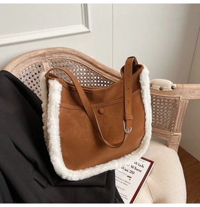 Brown suede bucket bag with white faux fur trim placed on a vintage rattan chair