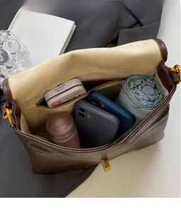Interior view of brown faux leather shoulder bag showing large capacity and zipper pocket