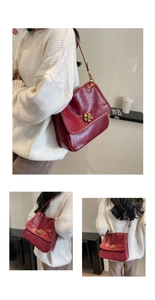 Detail of red vintage shoulder bag featuring glossy oil-wax texture and golden flower clasp
