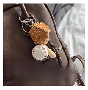 Dettaglio di ciondoli a forma di guantone, palla e mazza da baseball su borsa in pelle