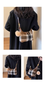 Detail of retro plaid wool shoulder bag with brown leather trim and fluffy pompom charm