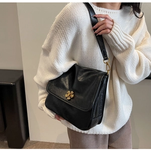 Close-up of black PU leather shoulder bag with vintage gold floral twist lock detail