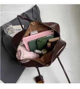 Detailed interior of brown PU leather tote bag showing large capacity and multi-pocket layout