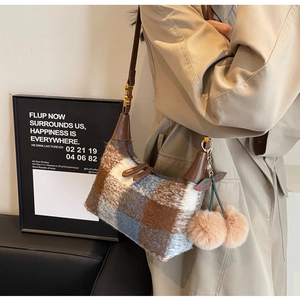 Detail of vintage plaid wool shoulder bag with leather handle and cherry charm detail
