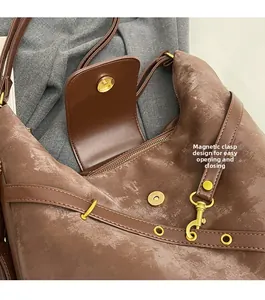Detail of a brown tote bag with magnetic snap closure and golden hardware components