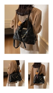 Detail of black vintage matte leather tote bag with plush bear and silk scarf charm