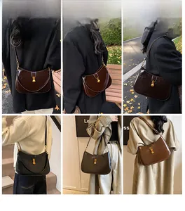 Detail view of vintage-style hobo shoulder bag with classic gold metal buckle and glossy finish