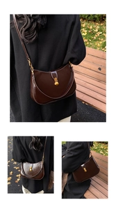 Detail of a dark brown half-moon leather bag featuring a vintage gold clasp and smooth texture