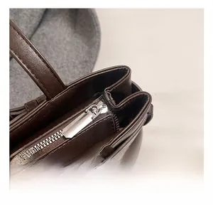Close-up of high-quality silver zipper and hardware on a vintage dark brown shoulder bag