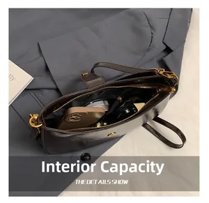 Interior view of brown faux leather underarm bag showing storage for phone and makeup
