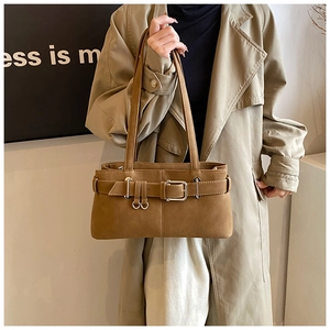 Detailed shot of caramel faux leather shoulder bag with vintage buckle straps