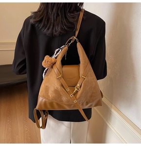 Detail of a brown patchwork tote bag with suede texture and a cute plush bear charm