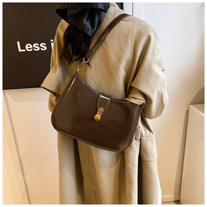 Detailed view of the dark brown hobo shoulder bag with glossy finish and gold metal buckle