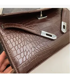 Detailed macro view of the brown crocodile pattern texture and silver metal clasp buckle