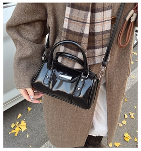 Detail of black faux leather Boston bag with metal studs and detachable shoulder strap