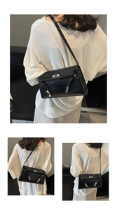 Detailed view of black crocodile pattern leather bag with silver metal swivel lock