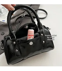 Detail of glossy black cylinder bag with functional front magnetic pocket for easy storage