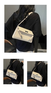 Close-up of beige crocodile texture shoulder bag with metallic clasp and Kelly style details