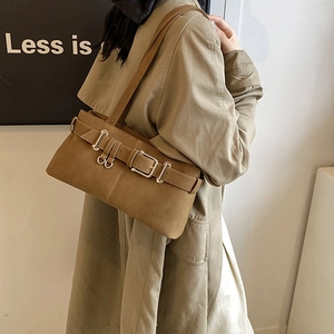 Brown leather motorcycle baguette bag with adjustable strap worn by a female model