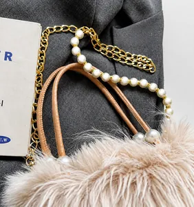 Detail of soft faux fur bag with imitation pearl strap and gold metal chain