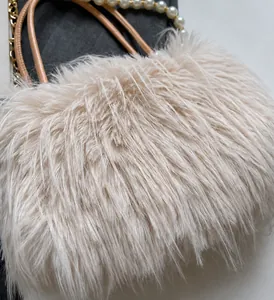 Close-up of soft faux fur texture with elegant pearl chain and leather handle detail