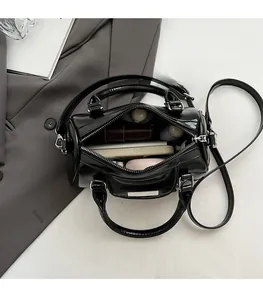 Top view of spacious interior in black leather cylinder bag with daily essentials