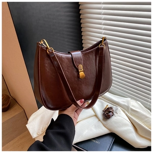 Detail of dark brown vintage crescent bag with gold buckle and adjustable strap