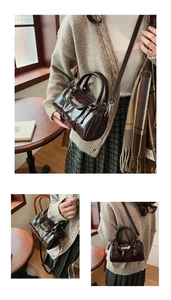 Detailed view of coffee brown leather cylinder bag with vintage metallic buckles
