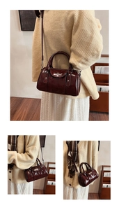Close-up of glossy burgundy patent leather cylinder bag with silver stud detailing