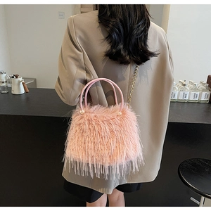 Detail of pink faux fur bucket bag with pearl handle and golden chain shoulder strap
