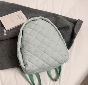 Détail de la texture matelassée vert clair et des coutures en losange du sac à dos en nylon