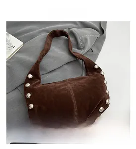 Detailed macro view of dark brown suede shoulder bag with silver rivet stud embellishments