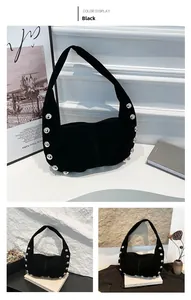 Detail of black matte suede hobo bag with large silver metal studs and wide shoulder strap