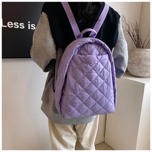 Gros plan d'un sac à dos violet matelassé montrant les motifs de losanges en nylon