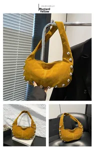 Detail view of brown suede shoulder bag with silver rivet studs and moon shape design