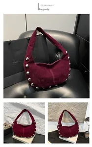 Macro detail of wine red suede hobo bag with vintage silver rivet accents and wide strap