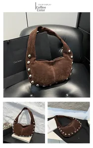Detail view of coffee suede shoulder bag featuring silver stud accents and half-moon shape