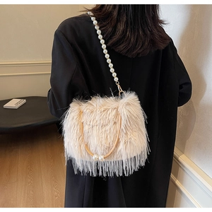Detail of plush apricot shoulder bag with faux fur texture and elegant pearl chain