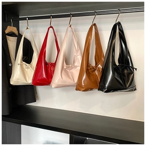 Detail view of glossy leather hobo bags with drawstring bow accents in multiple colors